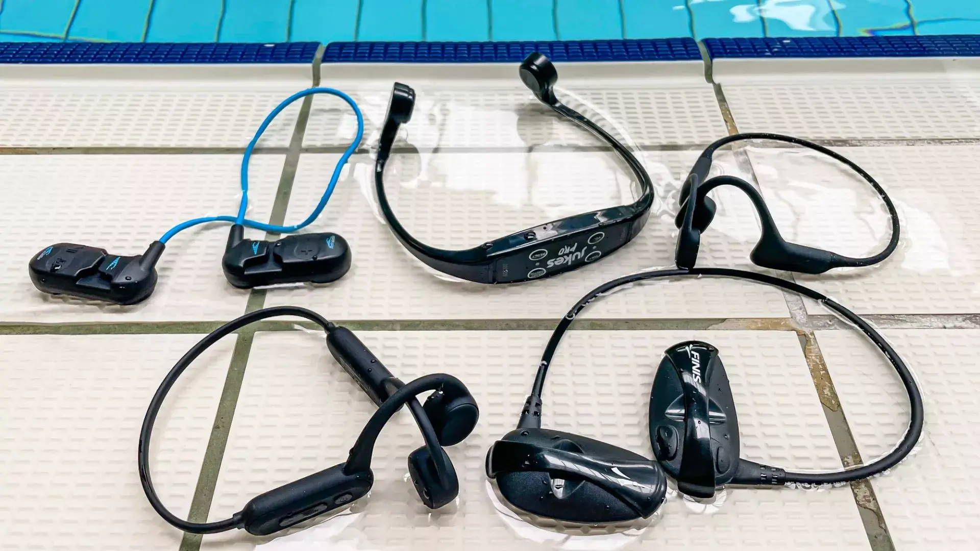 물이 있는 수영장 바닥에 놓인 여러개의 방수 이어폰